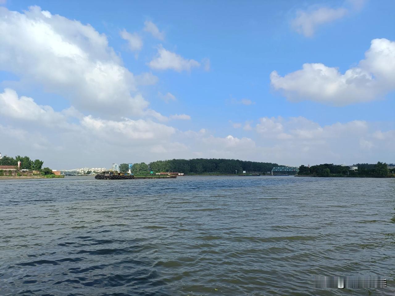 通榆河与新洋港交汇处，河宽水清，风高浪急，水流拍打岸边，绽开无数朵浪花。湛蓝的天