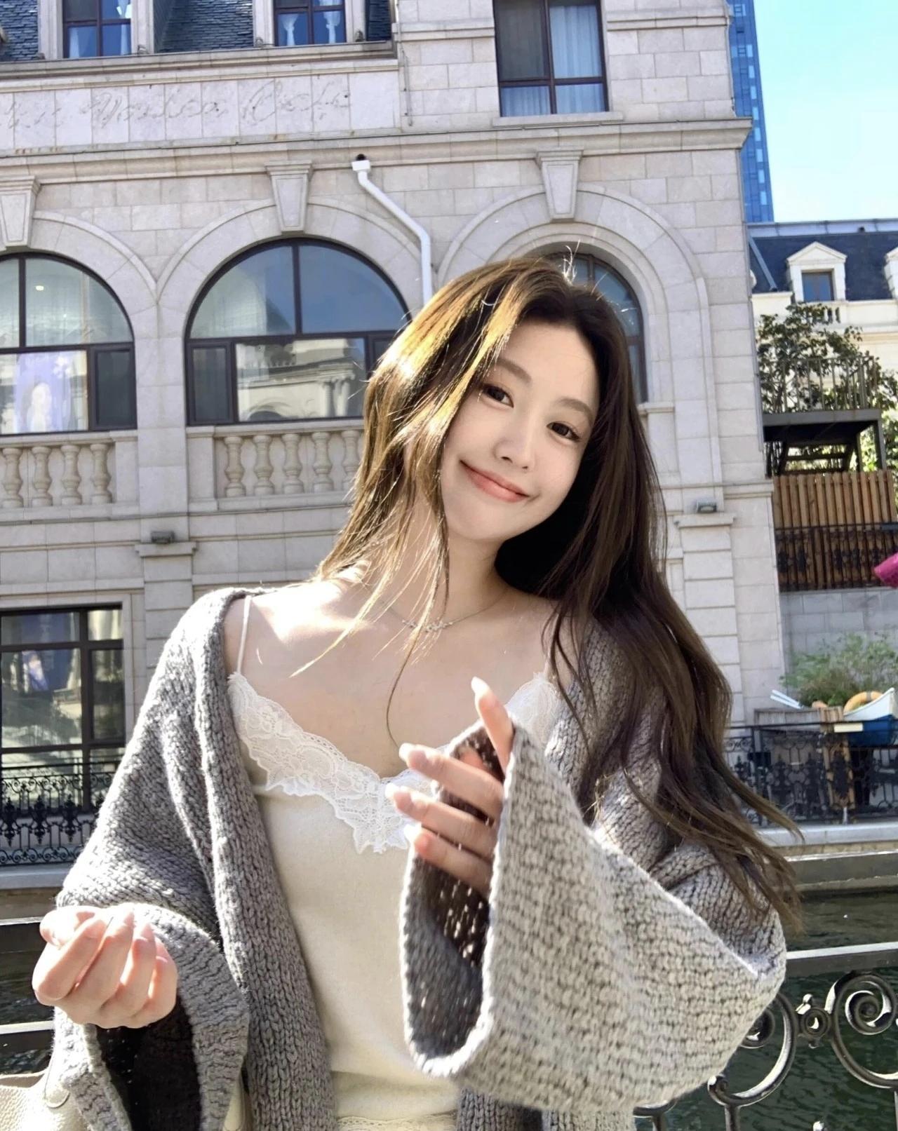 阳光明媚的一天，少女在古典建筑前微笑。