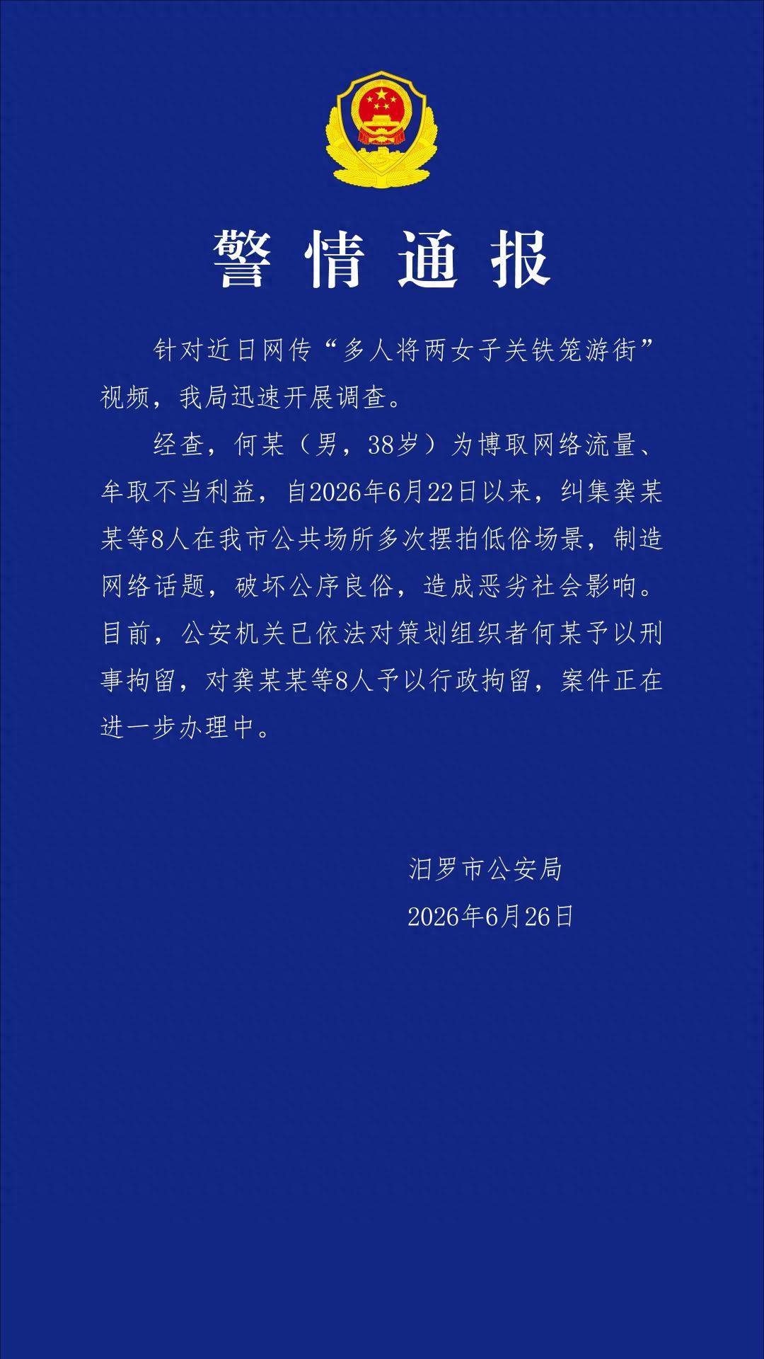 湖南岳阳，两名女子和一条小狗被关在铁笼中游街示众，旁边几名男子四处宣扬这两名女子