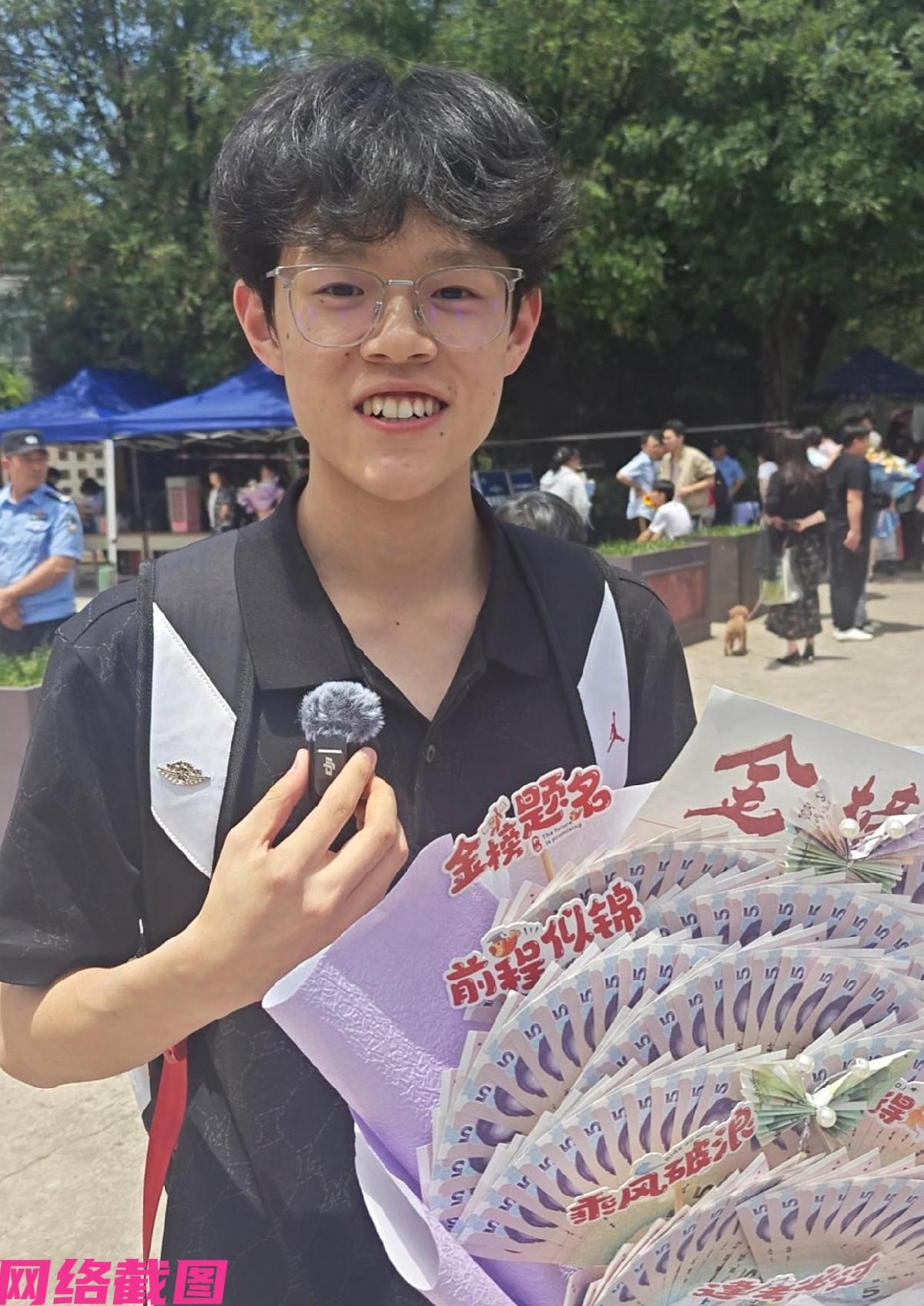 西安曲江有家长妈妈抱着一束紫色花束等待自家孩子走出考场，因考试选择科目已全部结束
