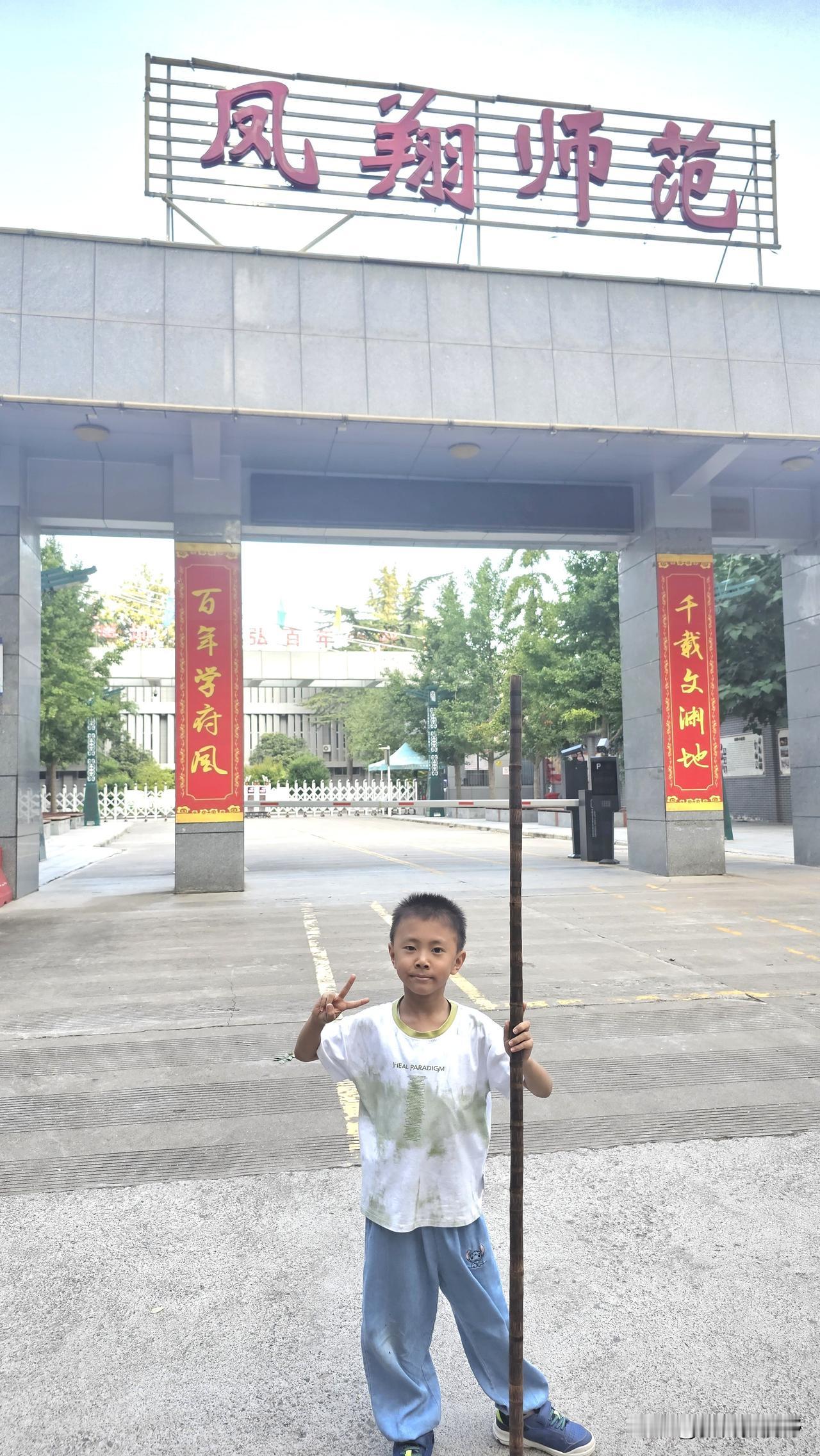 小朋友在凤翔师范门口拿着一根棍子捡棍子的男孩 两根棍子 棍子教学 少儿武术表演棍
