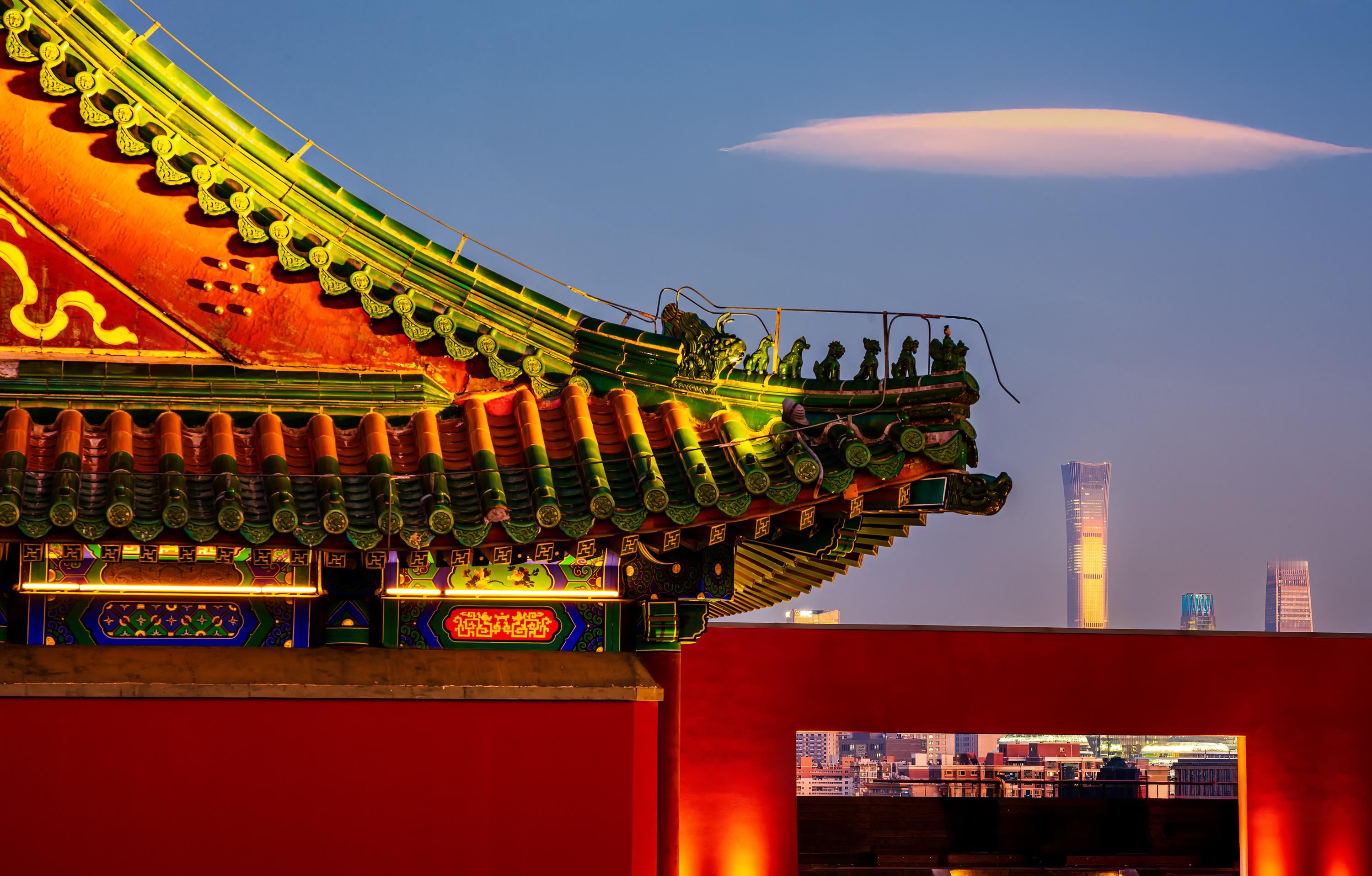 夕阳镀亮琉璃飞檐，神兽遥望中国尊。红墙拱门框住天际，暮色里古今相融。哈苏X2DI