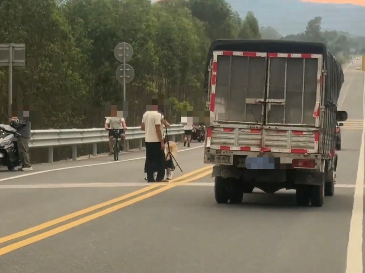 9月7日，网友反映：玉林一双实线道路上有多人在车流中拍照。这些人是不是都不要命？
