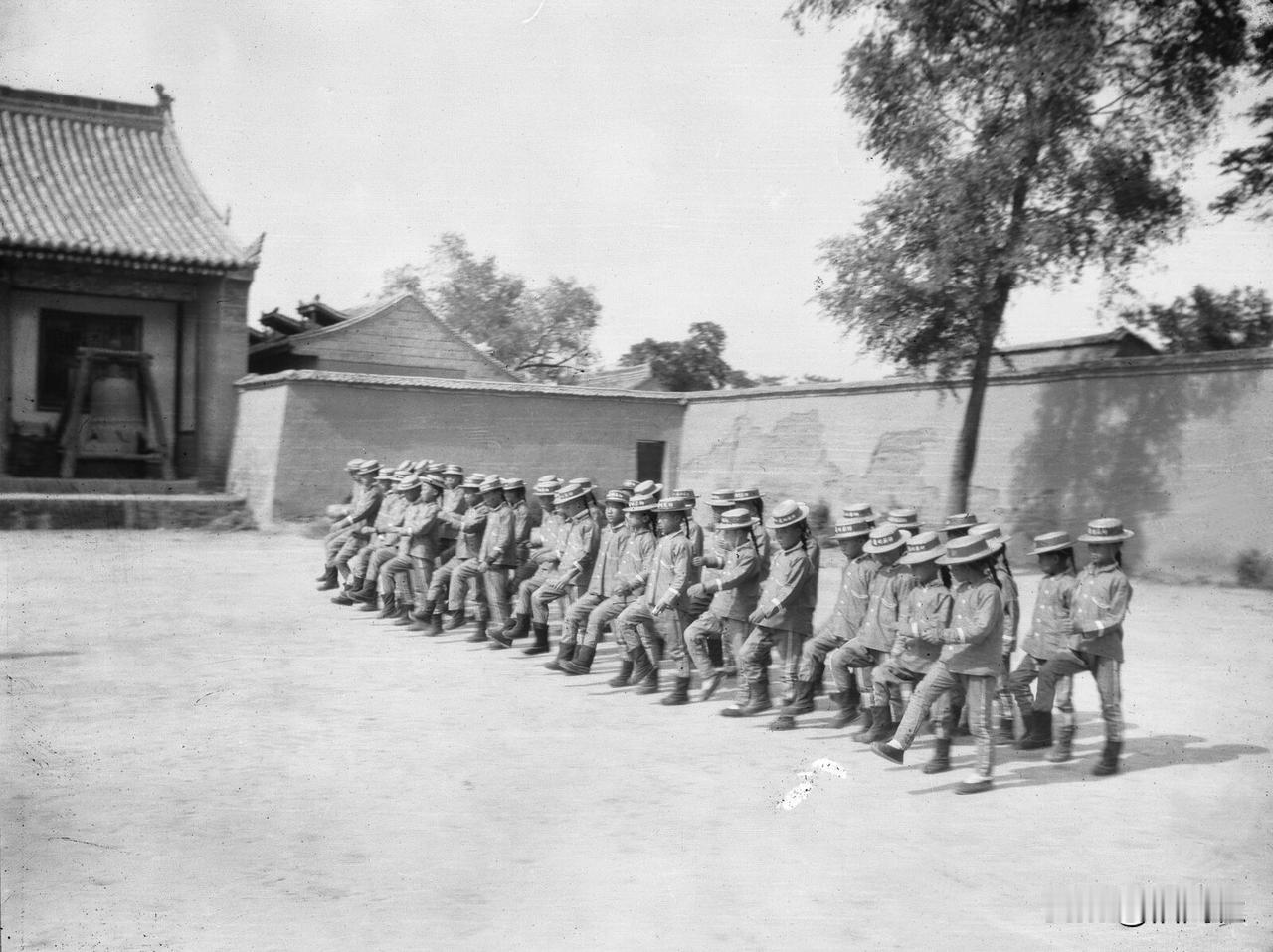 1906年西安，留长辫、穿西式军服的孩子们正在操练正步。

清末新政启动后，“编