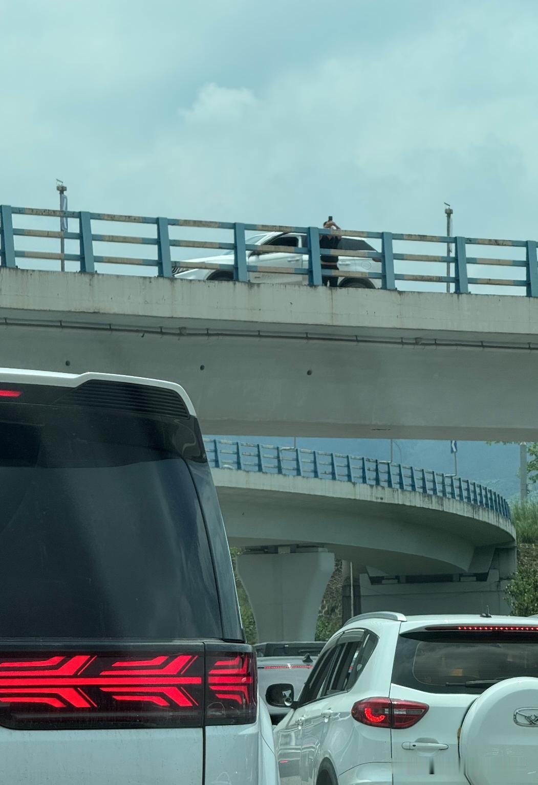 堵车吃瓜！
看到我们下面路上堵车，这个司机直接在高桥上停下来漫不经心的拍照和拍视
