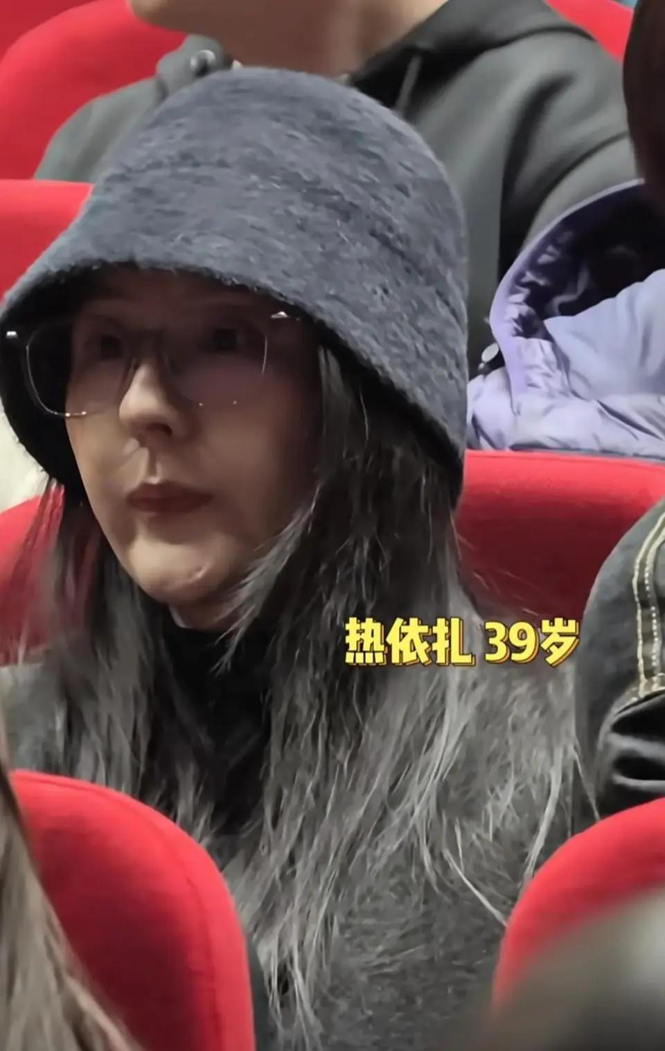 39岁的热依扎现身电影《长夜将尽》首映礼，戴着一顶灰色帽子，素颜出镜，皮肤状态虽