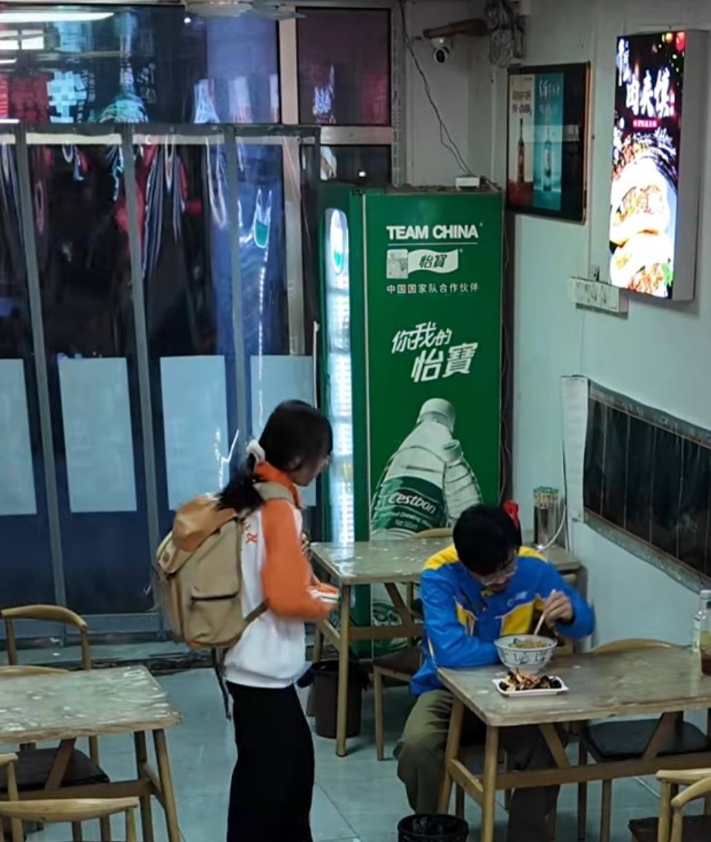 深夜的小饭馆里，暖黄的灯光映着热气腾腾的碗碟，闪送员正低头吃面，老板在后厨忙碌。