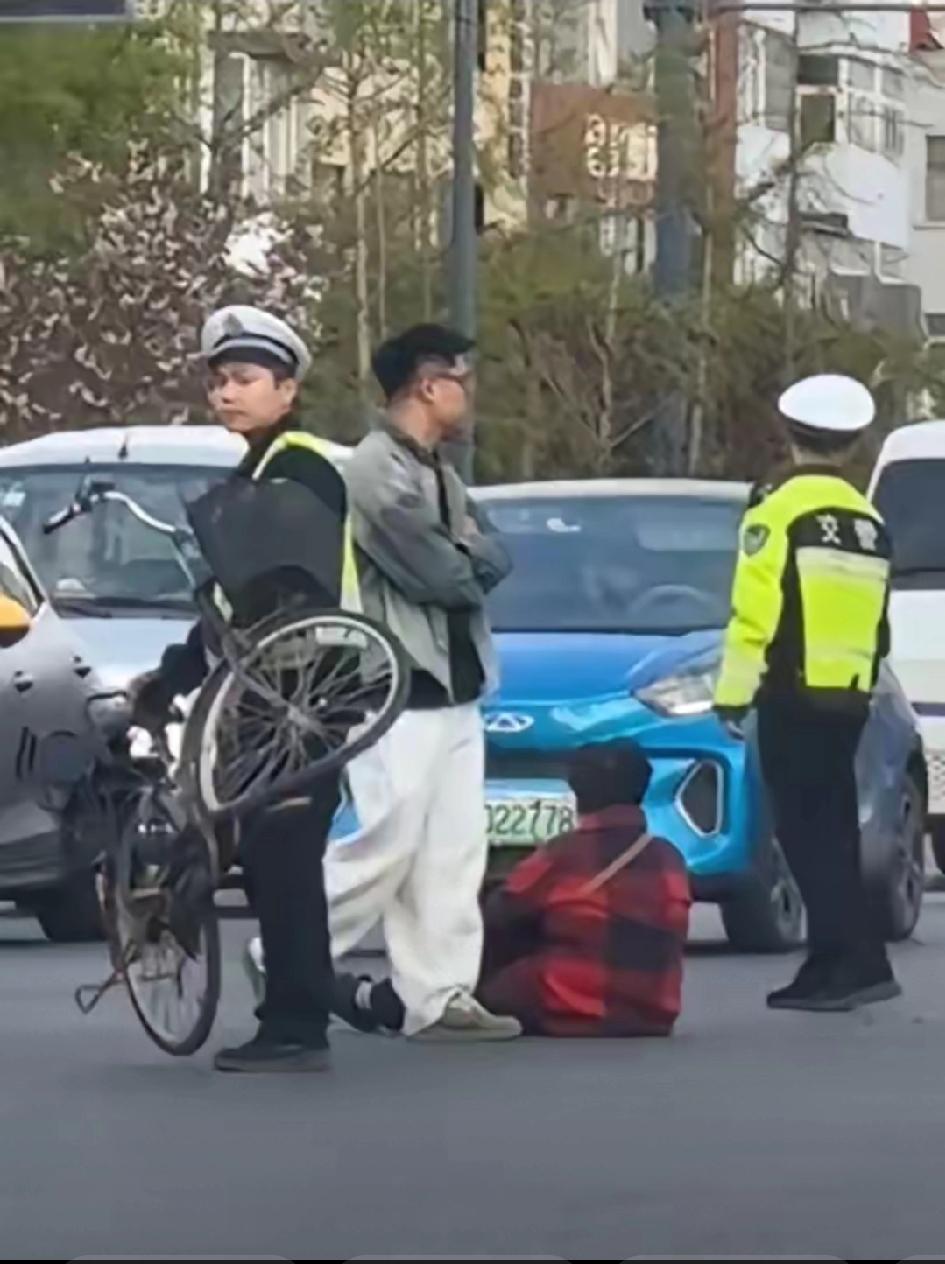 扶不扶，交警手里的自行车似曾相识，车圈都撞的卷起来了，阿姨坐在路中间，小哥双手交