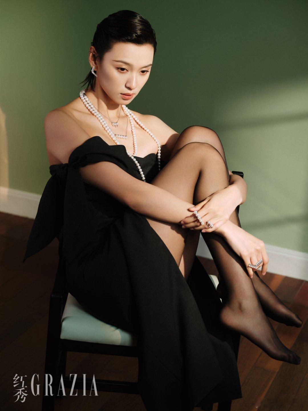 王丹妮镜面映出红唇锋芒，珍珠项链在颈间跳圆舞曲。墨绿光影里红袍如焰，指尖轻触涟漪