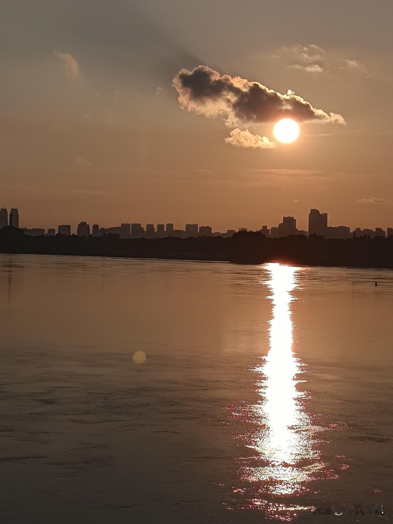 落日松花江。
落日松花江，在中东铁路桥那边，晚霞红满了天。游客在桥上观看美景。踏