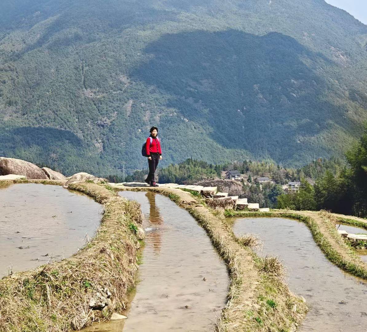站在梯田的水径上，身后是层叠的青山，眼前是悠悠的碧水。春日的风轻轻拂过，心里格外