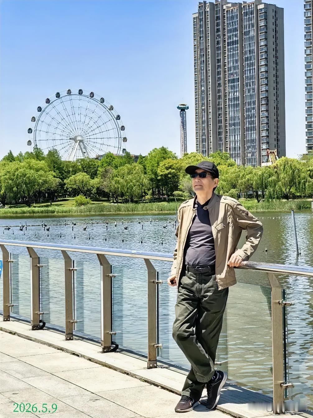 今天天气晴好，我来到公园湖边散步，架起手机自拍下了这张照片。湛蓝的天空下，湖水波