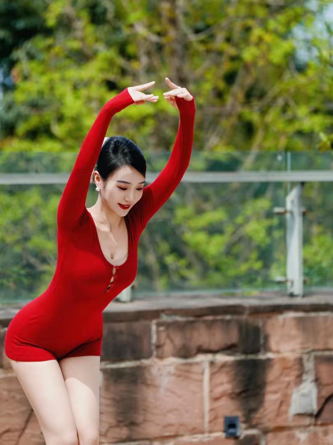 优雅红衣舞者，绿意盎然背景，动感与宁静的完美结合。