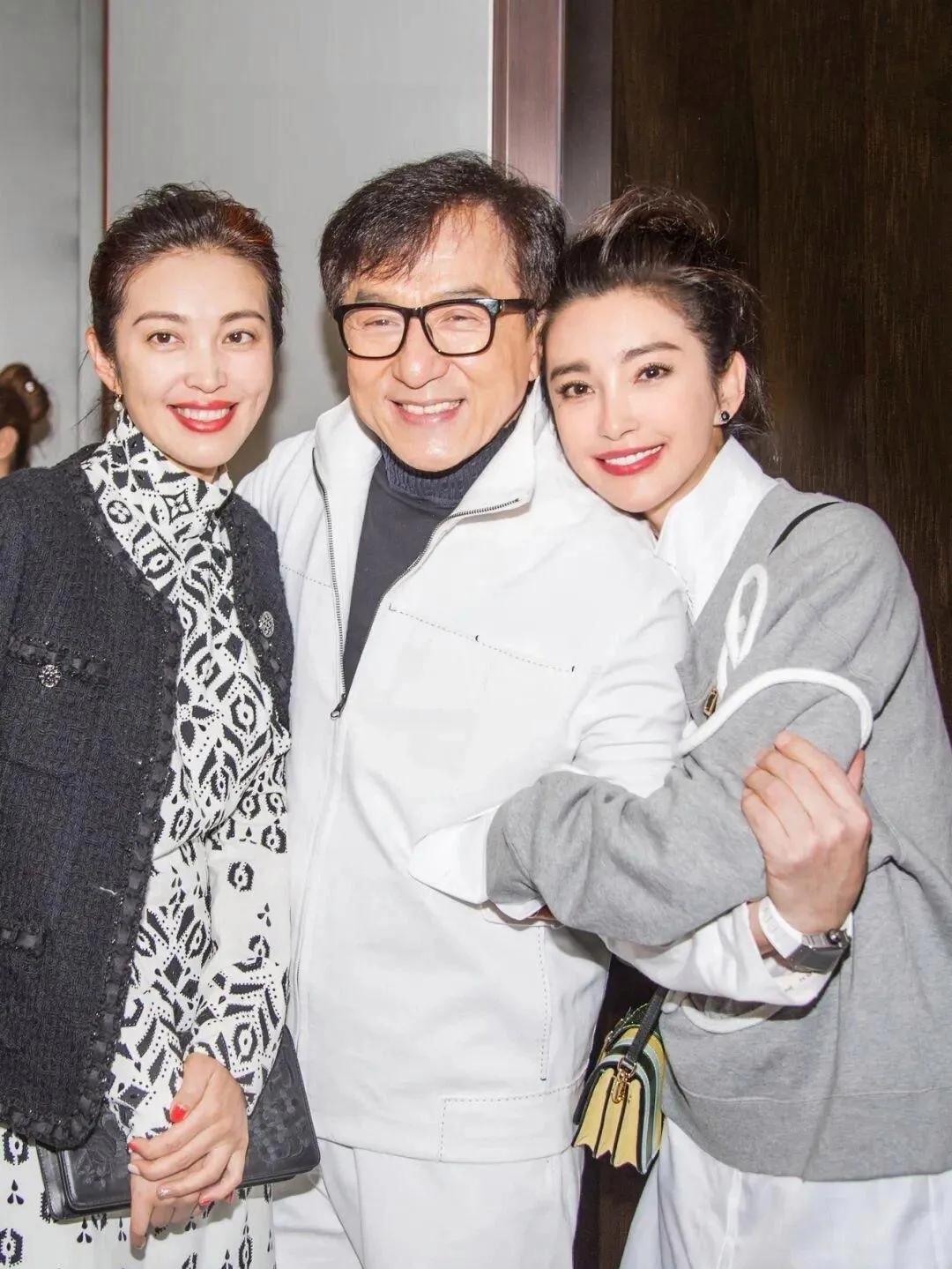 成龙右边的是李冰冰，丸子头，一身休闲的打扮，少女感十足。左边的这位美女和李冰冰看