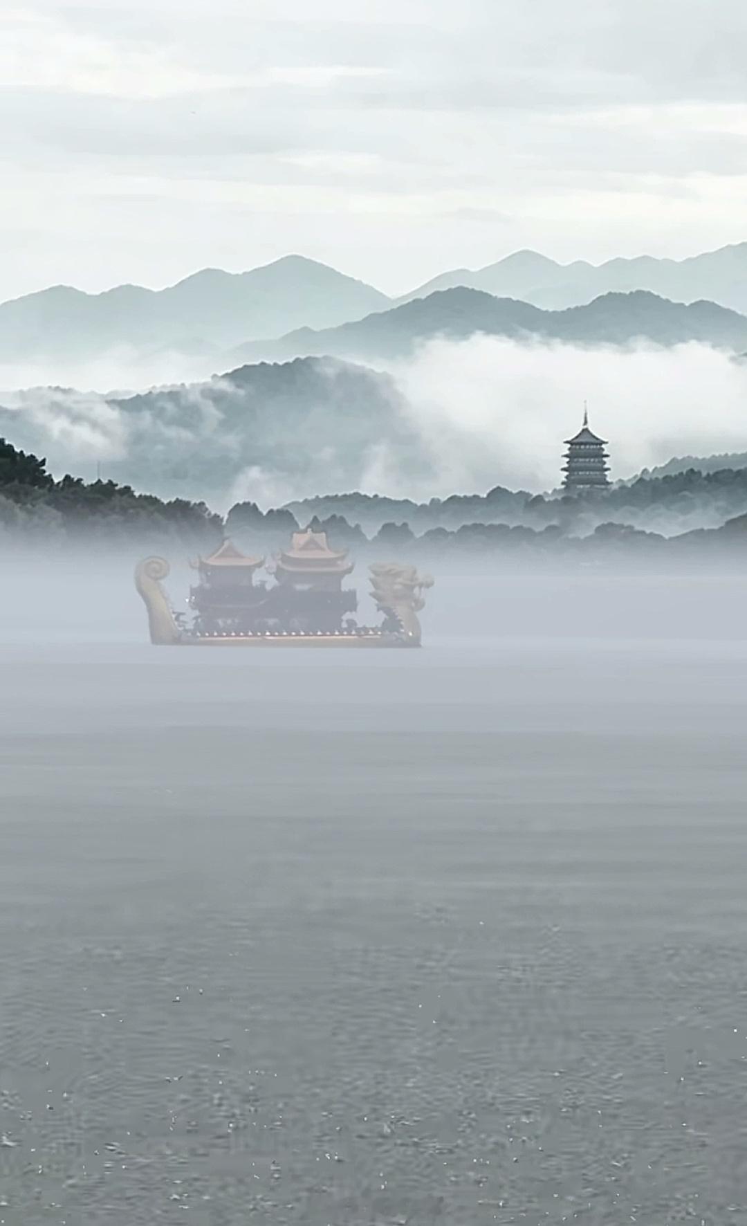 西湖突下暴雨游客蹲断桥上躲避雾西湖真的是杀疯了，这雷峰塔云雾缭绕的，还配一首渡情