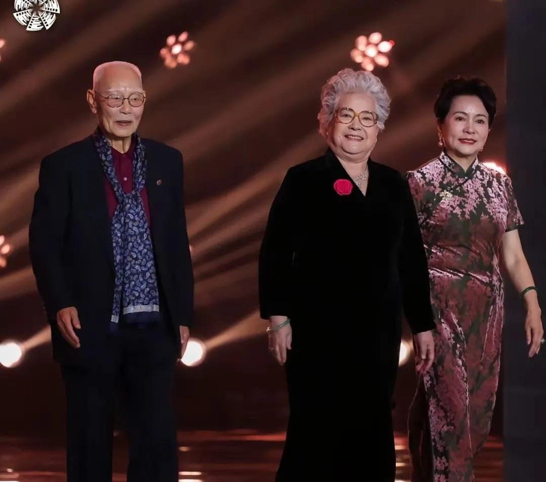 这位一袭黑衣的老演员，年轻时在电影《战火中的青春》（图二）中扮演一位女扮男装、飒