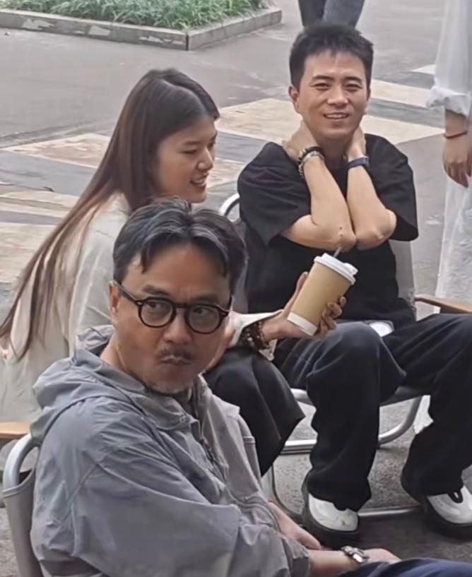 长沙街头，一个大叔坐在路边，花白头发，脚踩人字拖，手里捏着槟榔，脸色有点蜡黄。路