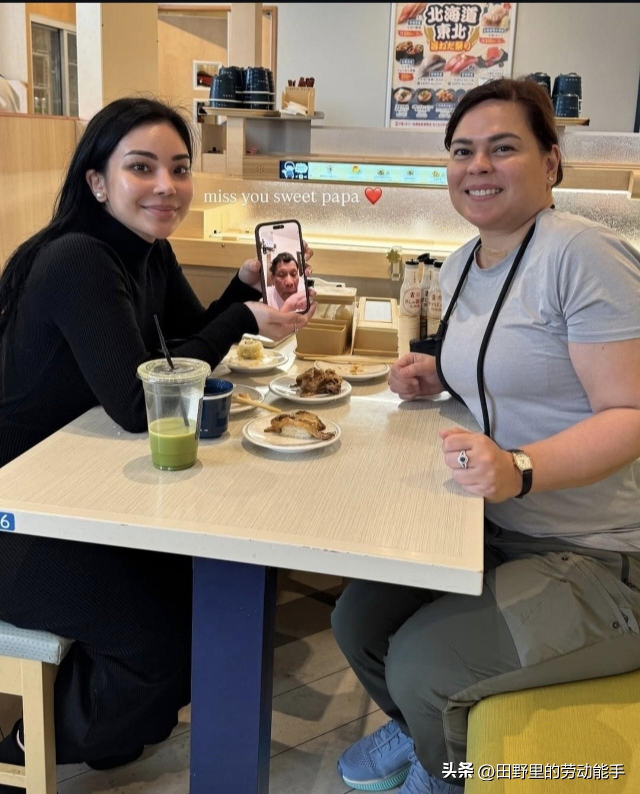 萨拉和妹妹在一家日式料理店用餐时，举着手机和羁押在海牙国际法庭的老爸杜特尔特视频