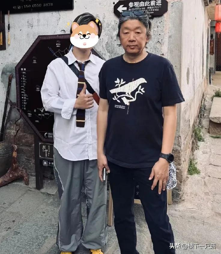56岁老狼和家人逛古村，为人很低调看起来很温柔。老狼儿子帮网友和老狼拍的合照，这