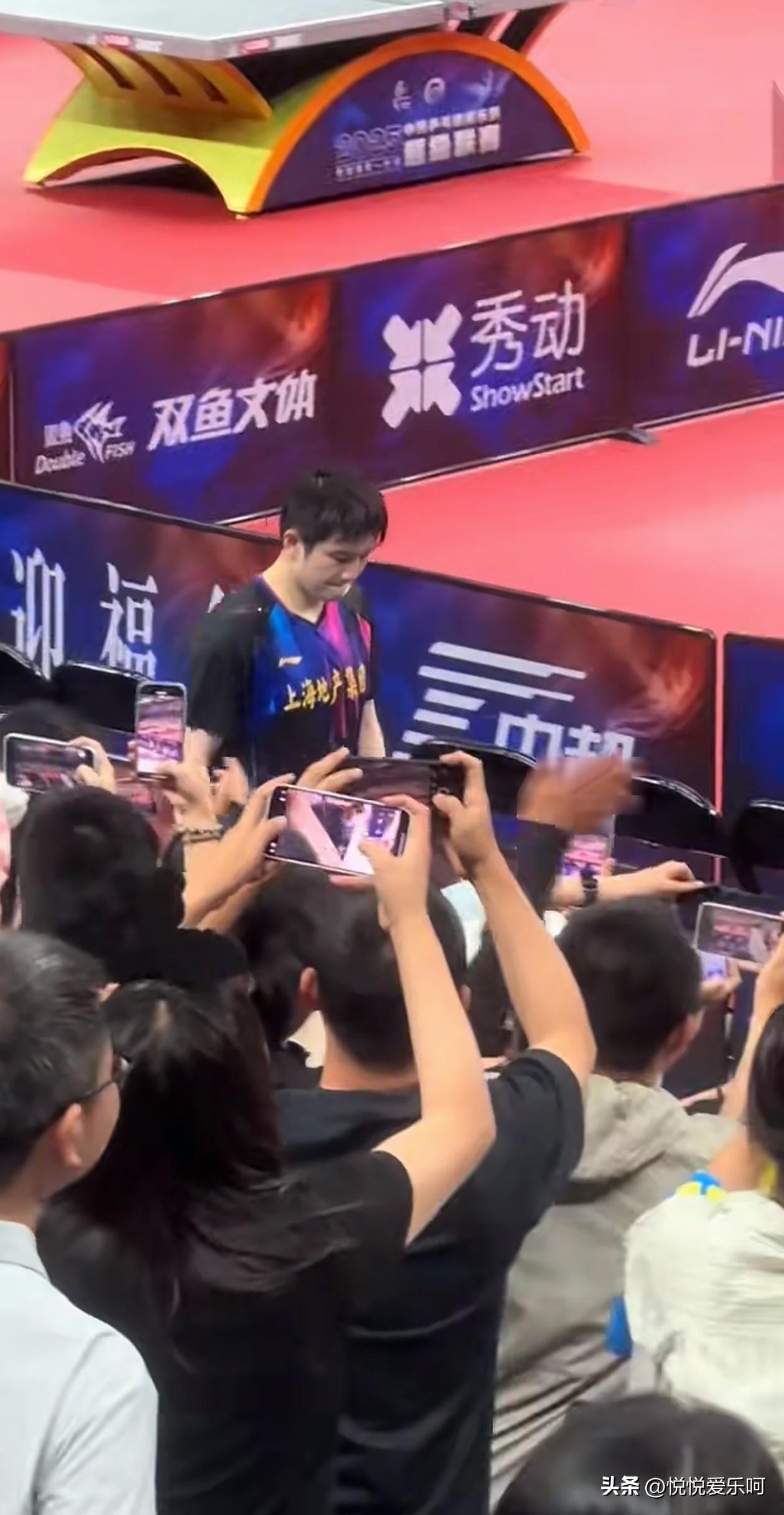 樊振东入场时，观众席人声鼎沸，所有的人举着手机都对着他，大声呼喊樊振东的名字，小