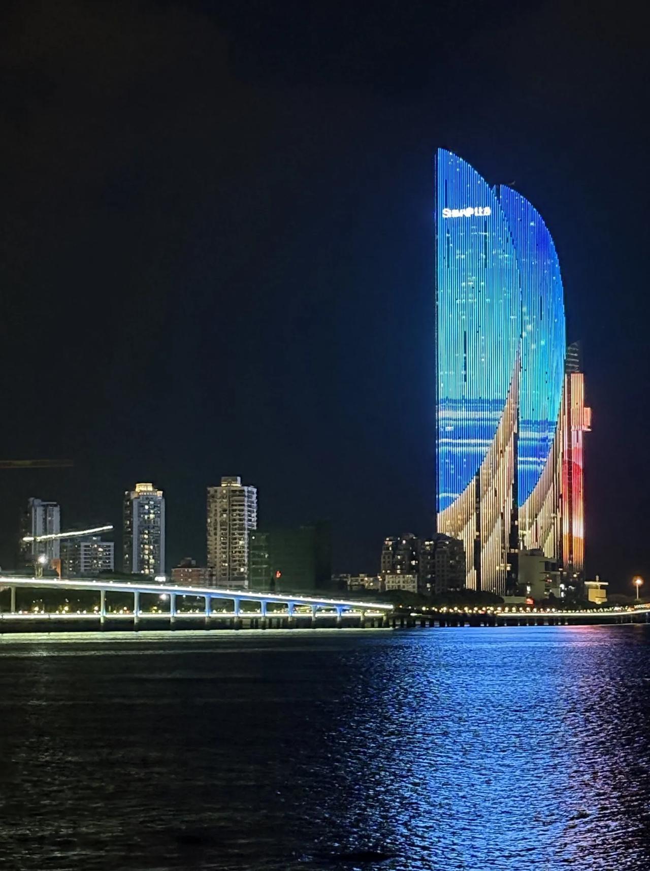 站在鹭江边看厦门夜景，像坠入一场“流动的星光宴”——双子塔的灯光是锋利的银刃划破