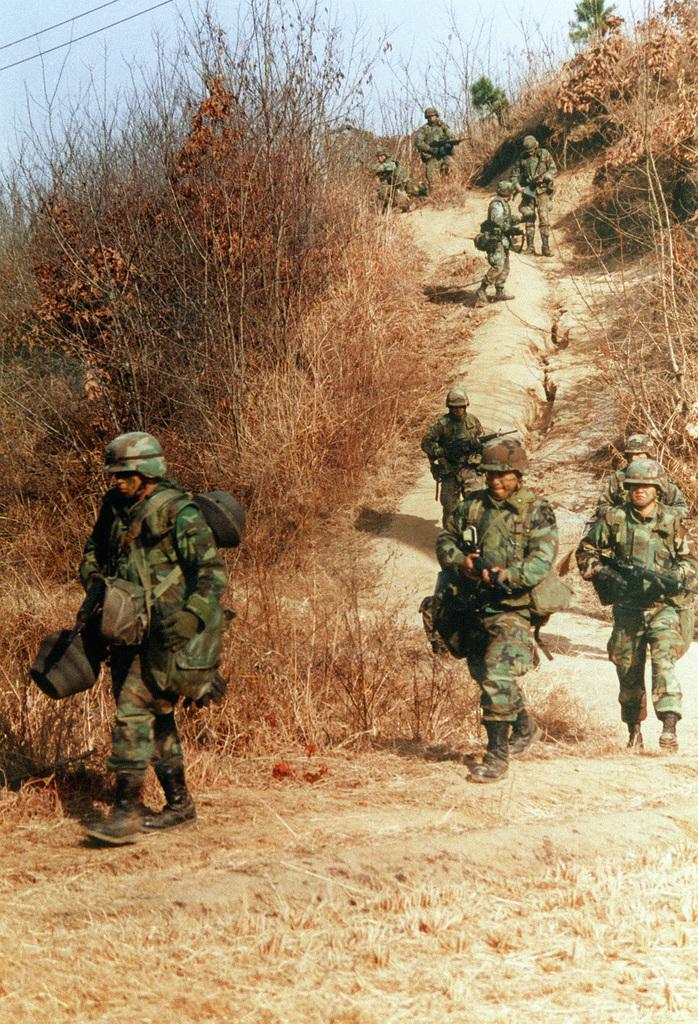 1991年，美国与韩国士兵在韩国台风靶场的实弹演习中执行巡逻任务。