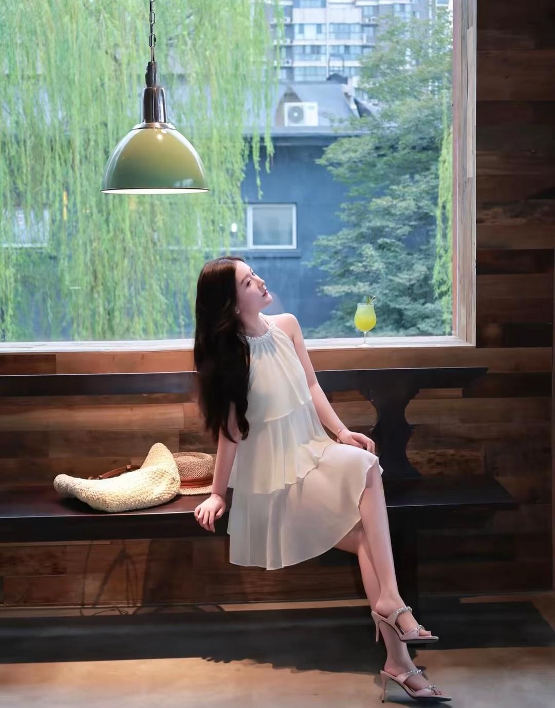 阳光洒进咖啡馆，她静静地坐在窗边，享受着悠闲的午后时光。