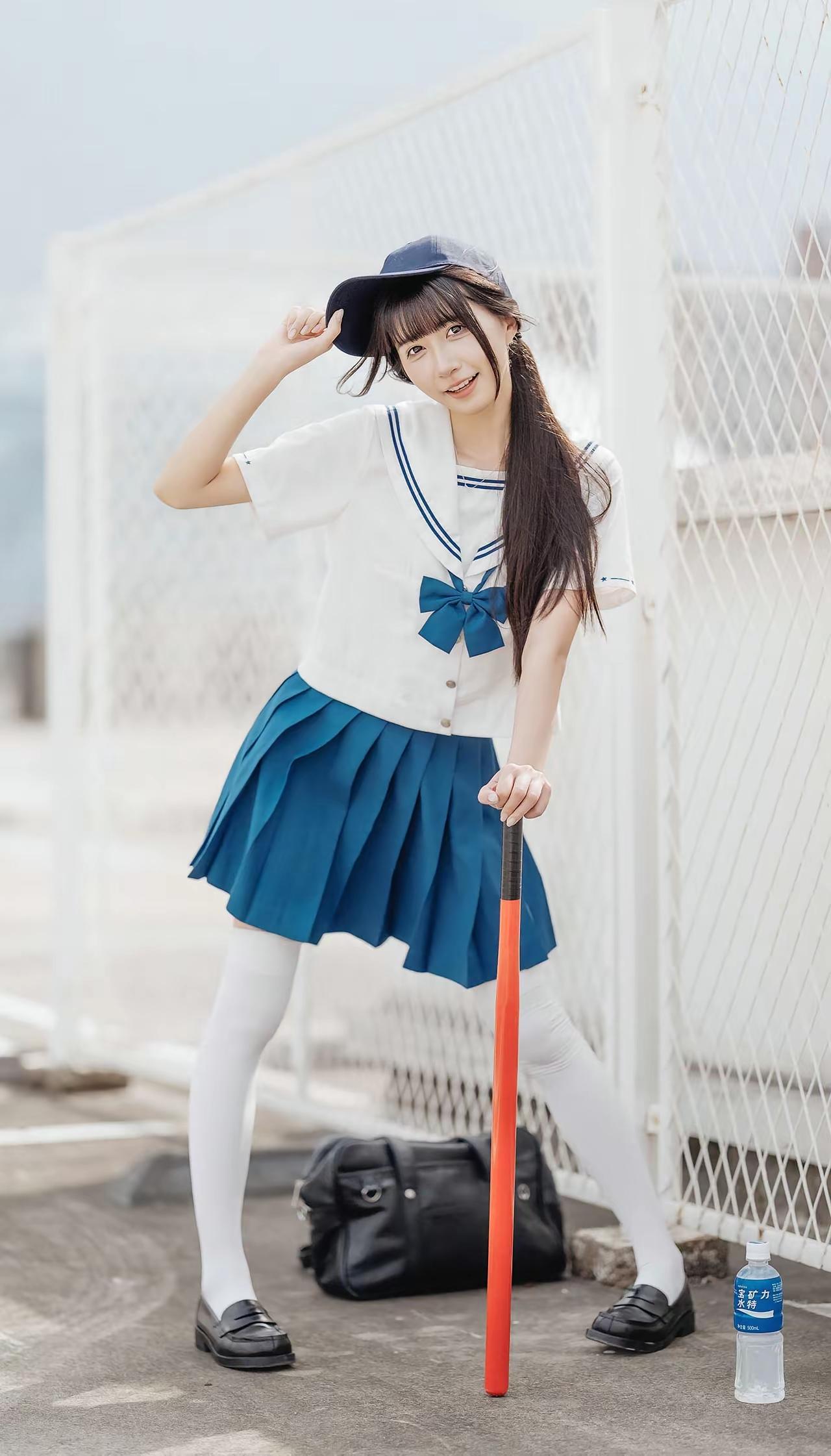 穿着水手服的女孩在运动场边休息。