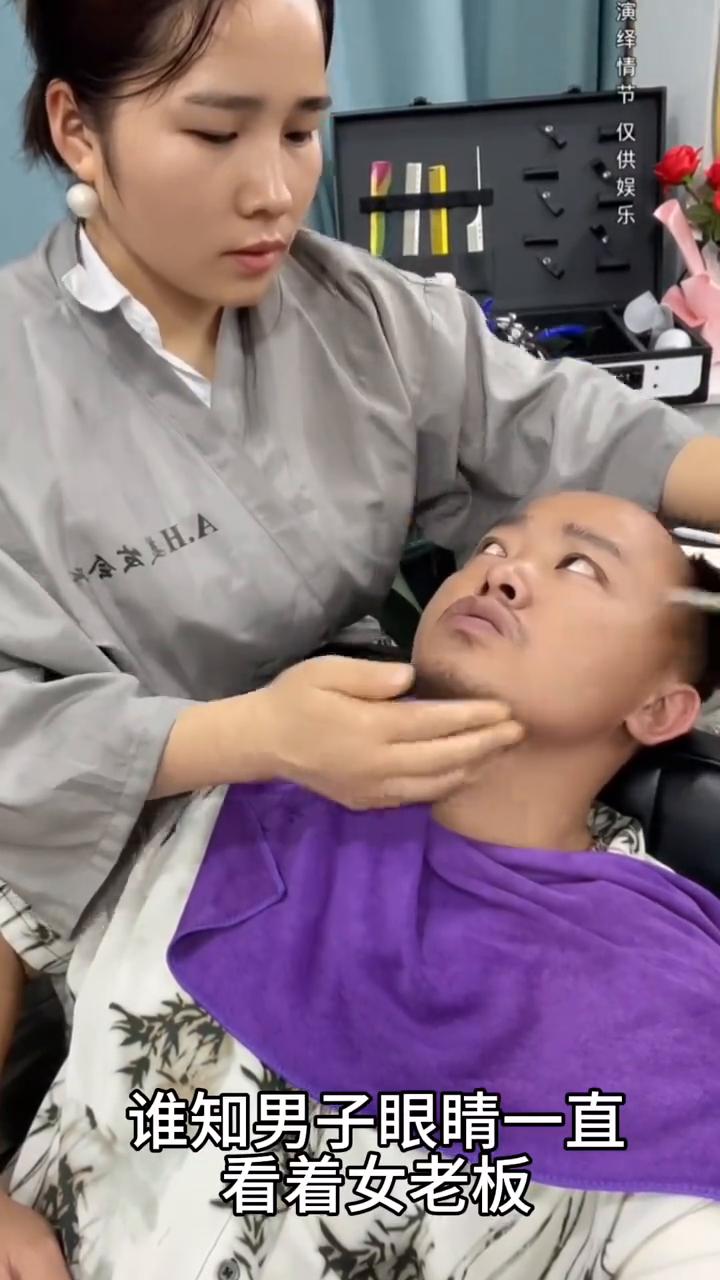 男子刮胡子总是盯着女老板看，这一幕真的太无奈了。
理发店老板给男子在刮胡子，谁知