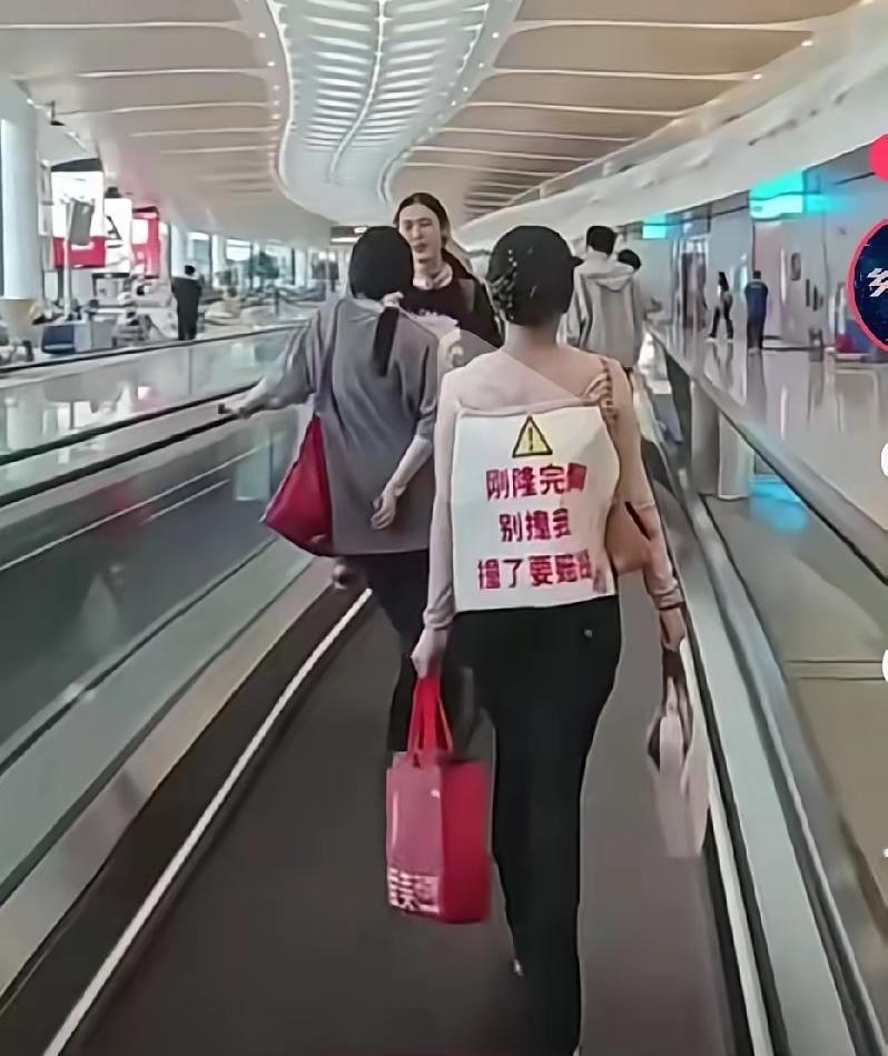 女子刚隆完胸回家路上，怕别人撞到她的胸，于是在后面挂了这样一个牌子，提醒告诉路人