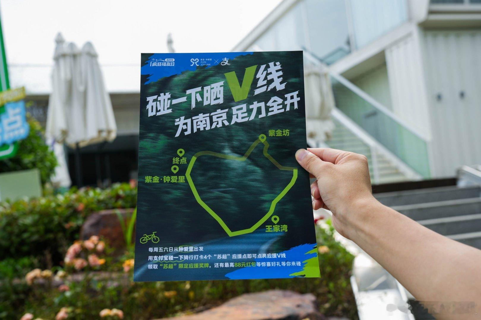 百店发支付宝助威袋为南京队加油周末特意来到紫金·钟爱里参加骑行活动，手持V字型邀