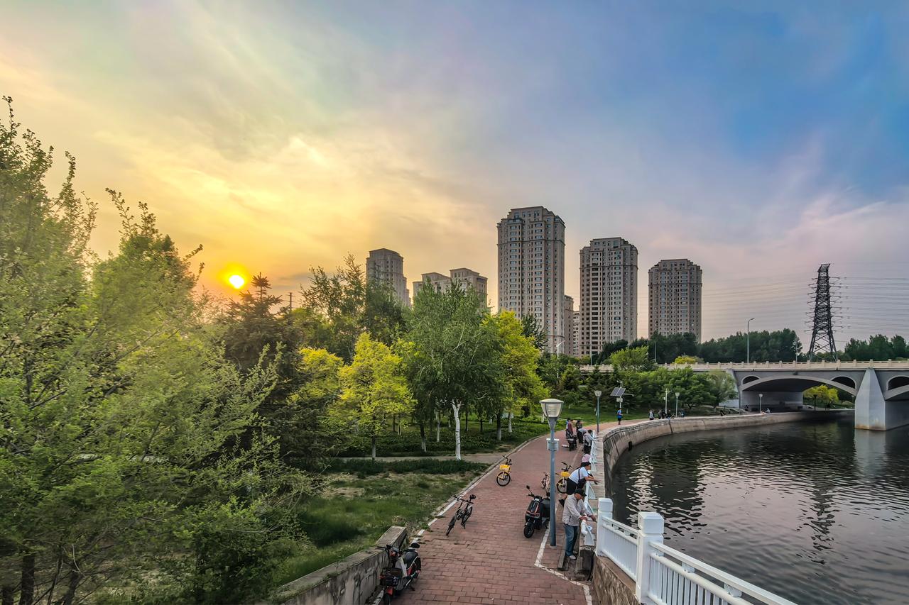 伊通河夕记

黄昏时分，立于伊通河西岸高台远眺，晚风轻拂，满城喧嚣渐归于沉静。