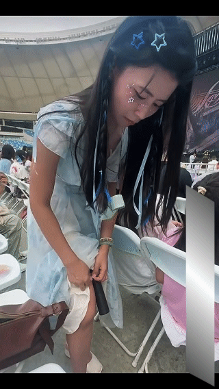 小姐姐参加张韶涵演唱会，趁着座位上没人注意，弯腰撩起裙子，把绑在腿上的东西偷偷拿