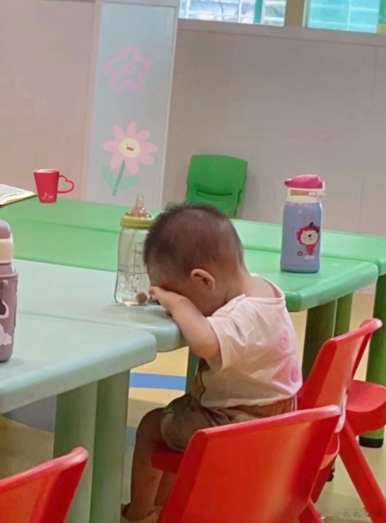 幼儿园里别人是水杯他是奶瓶，好可爱的宝宝，跟小玩具一样。这么早就上学其实也是无奈