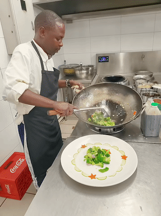 非洲一家中餐饭店里。
一名曾在中国广东生活过的黑人厨师正在制作广东粤菜“清炒蒜蓉