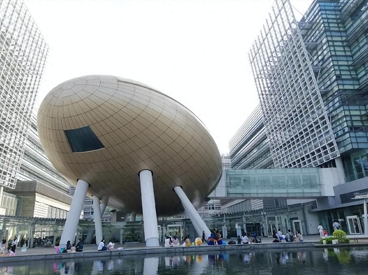 尖沙咀东部的玻璃幕墙建筑里，人群在地下力学厅排起长队。

红色车架的自行车静静停