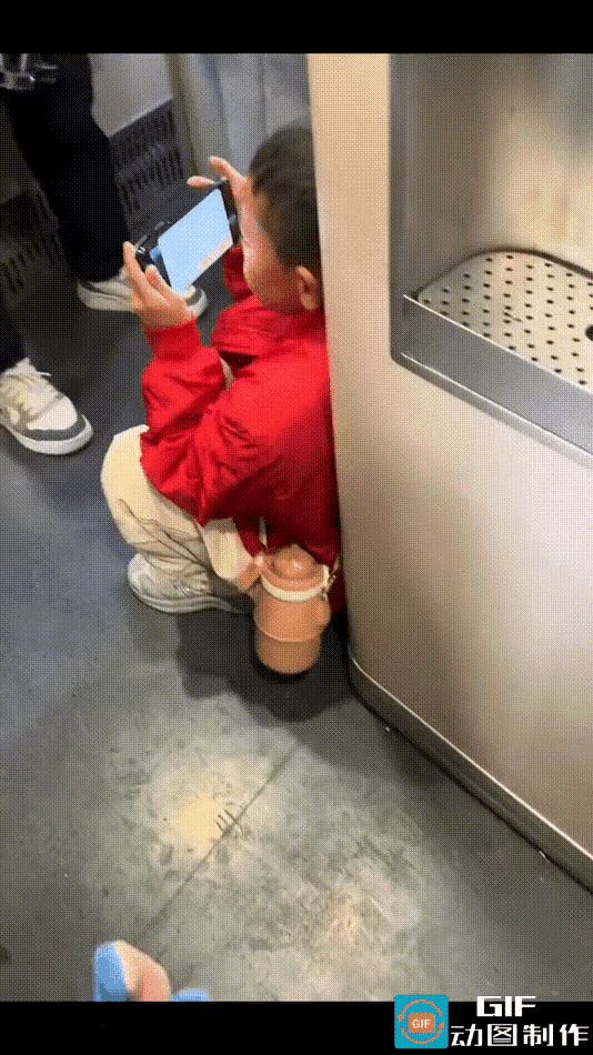 小孩在晃来晃去的车厢里玩手机，脸都快贴到屏幕上了。网友无意间一看，吓一跳——这娃