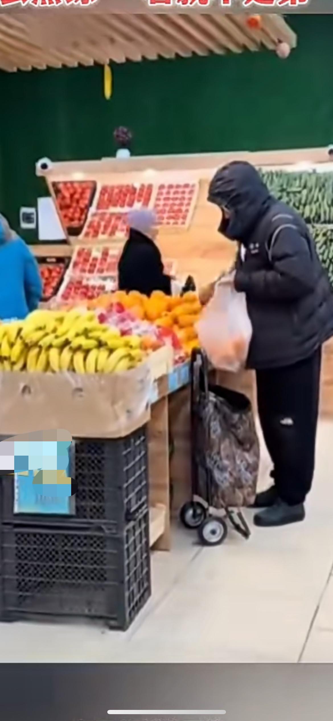 12月12日，男子在超市挑水果 ，有的扔进购物袋 ，有的扔进小拉车，网友:这么熟