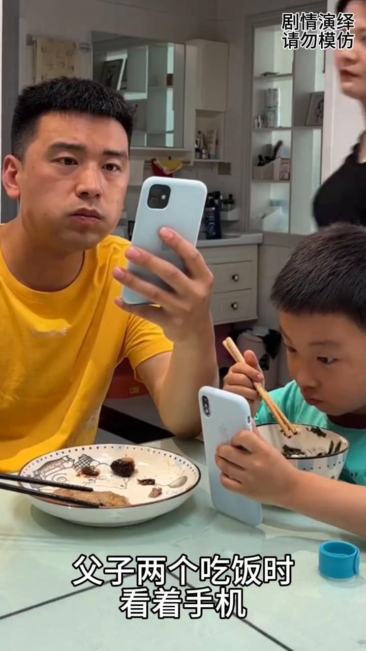 爸爸吃饭时带着儿子看手机，下一秒媳妇的做法太有才了。
父子两个吃饭时看着手机，媳