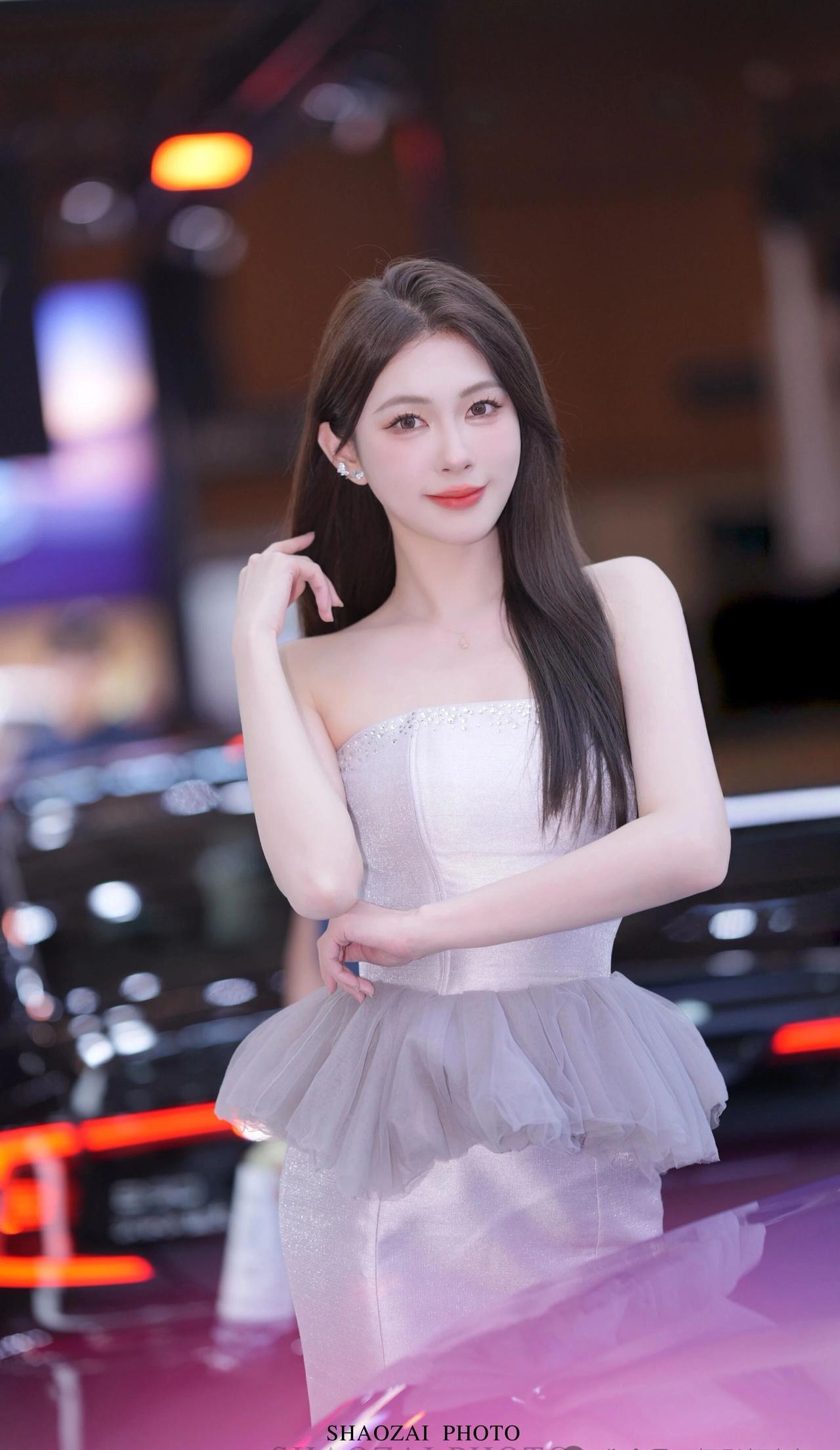 抹胸领口镶有精致水钻，腰部叠加薄纱荷叶边，鱼尾裙摆修身垂顺，在灯光下泛着细腻细闪