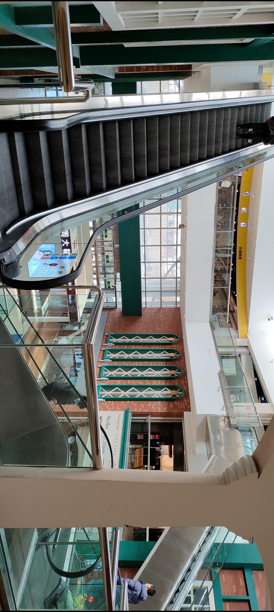 🏙️ 宽敞明亮的商场，扶梯和玻璃护栏，时尚大气！