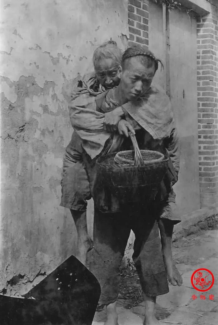 晚清老照片：一个年轻人背着老母亲乞讨。晚清战乱多、天灾多、苛捐杂税多，底层百姓的