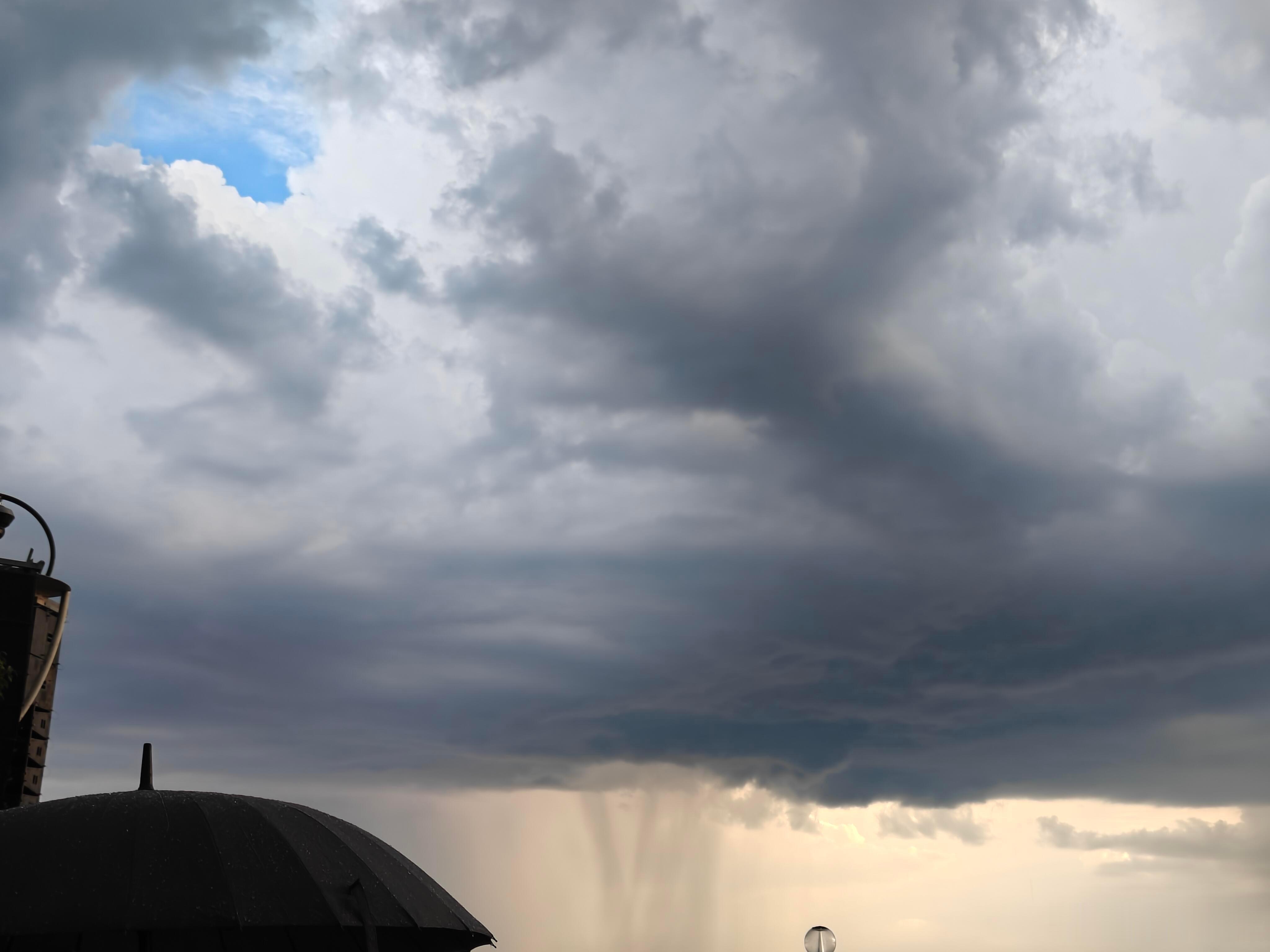 杭州上空现罕见雨幡景观杭州上空出现难得一见的自然奇观雨幡，厚重云层之下垂落大片朦