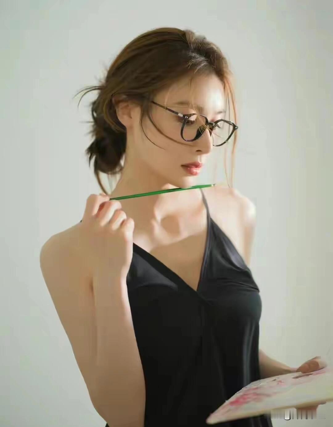 隆妮午后画室写真文艺气息！

一身着简约黑色吊带长裙，头发松散挽成低丸子，几缕碎