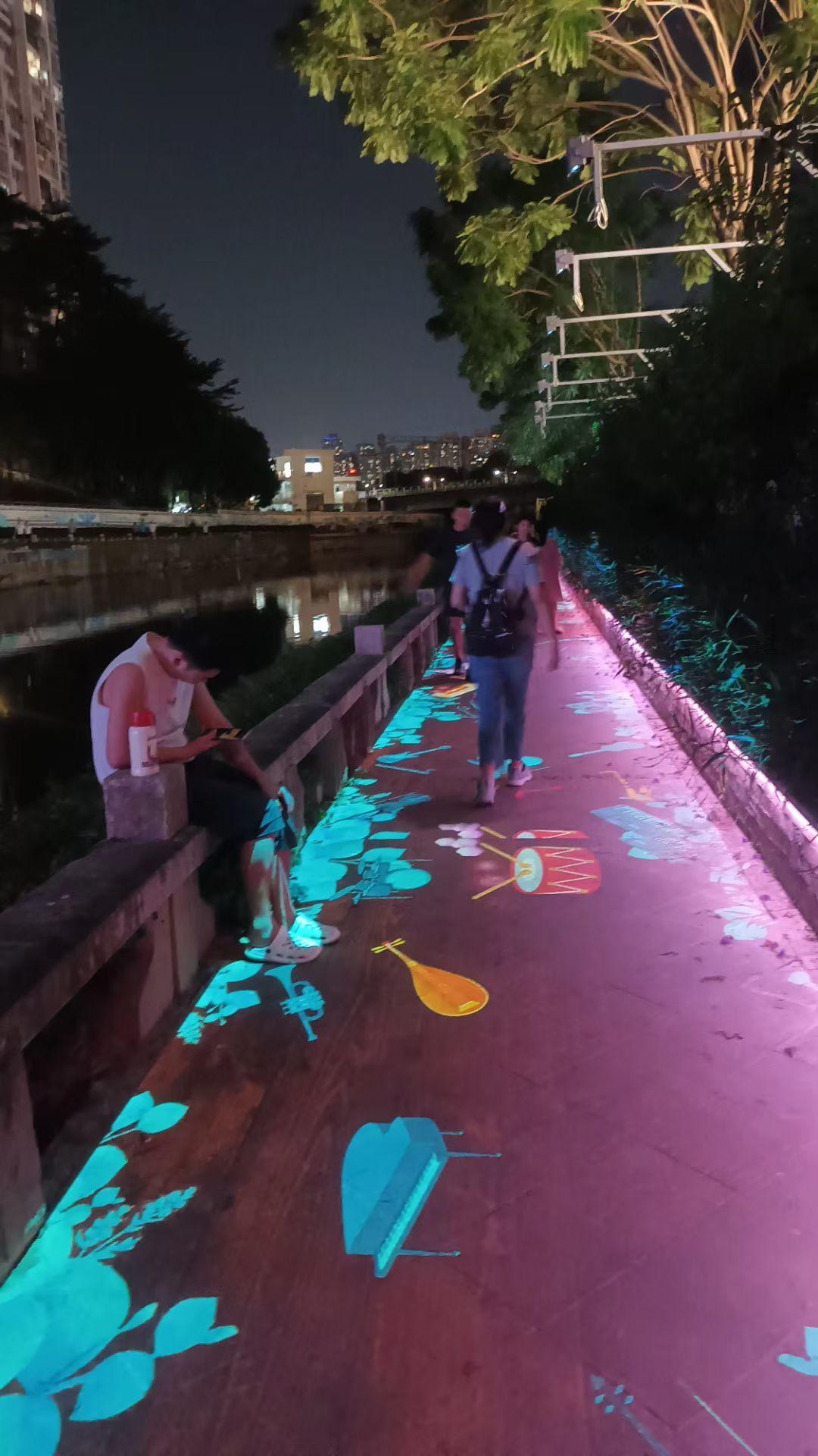 深圳最早开发的罗湖区，入夜沿着一內河岸漫步，弱光下一座五层高老旧房子入口灯笼闪亮