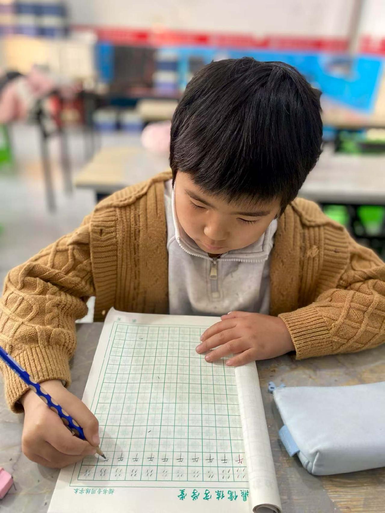 专注的小学生在教室里认真写字，可爱又勤奋！📚👩‍🏫