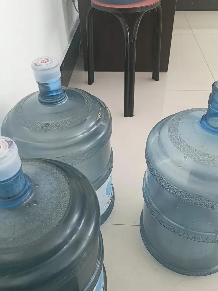 几个大水桶放在地上，准备装水。大家说喝这个大桶水便宜，还是家里安净水机便宜呢？这