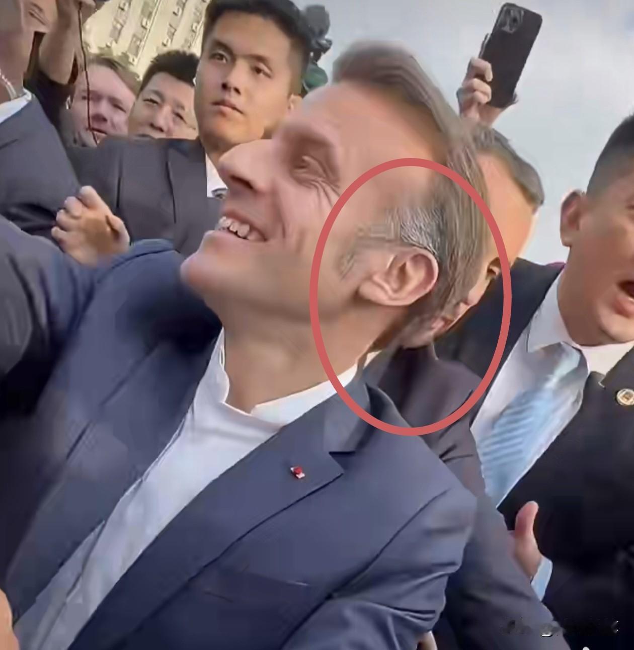 看到没？在与四川大学的同学们亲切握手时，近距离拍到马克龙的头发，发现发鬓的白发已