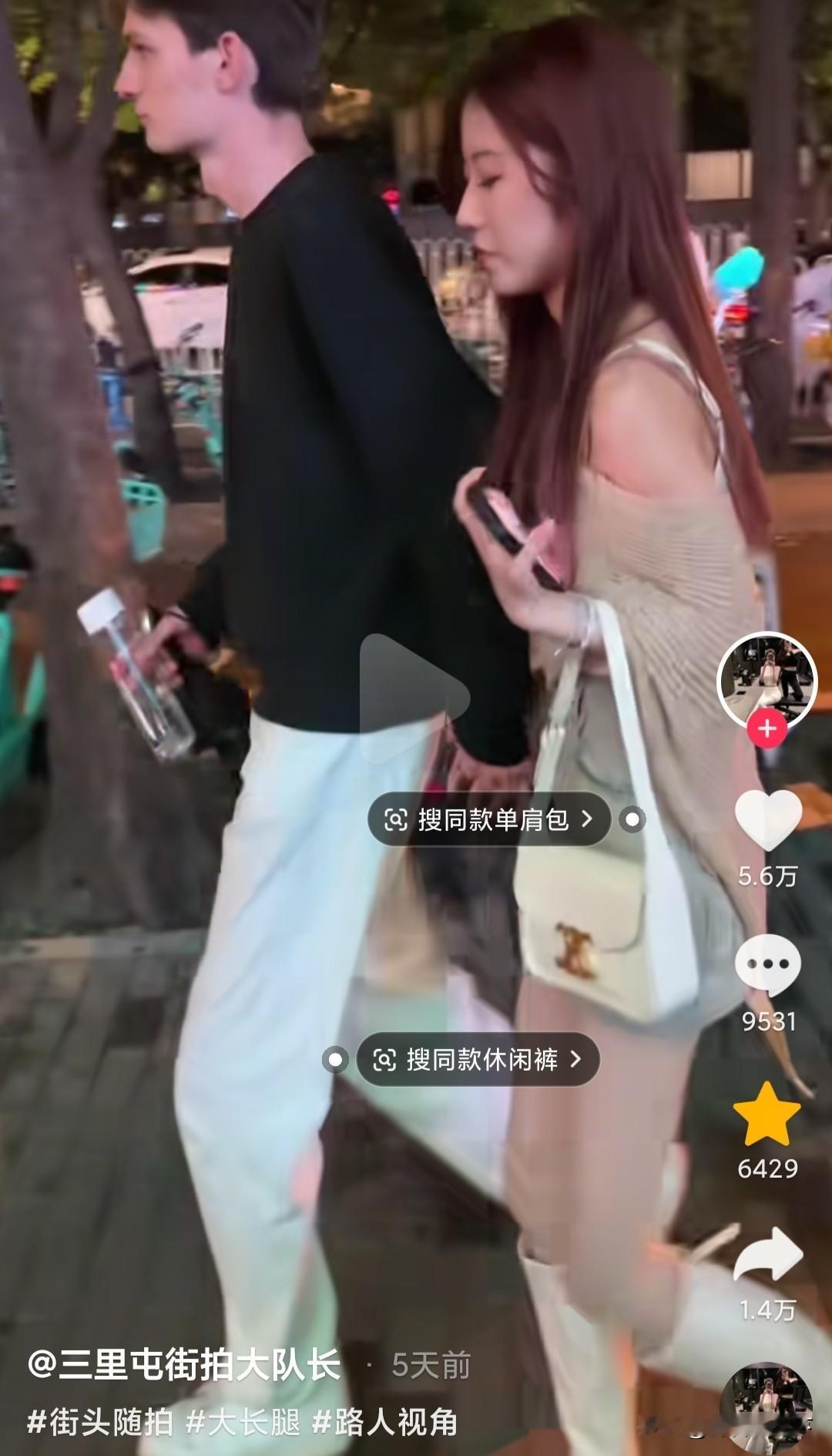 三里屯一位身材修长的外国男子，牵着一位中国美女路过，拍视频的老哥高呼，大哥真有福