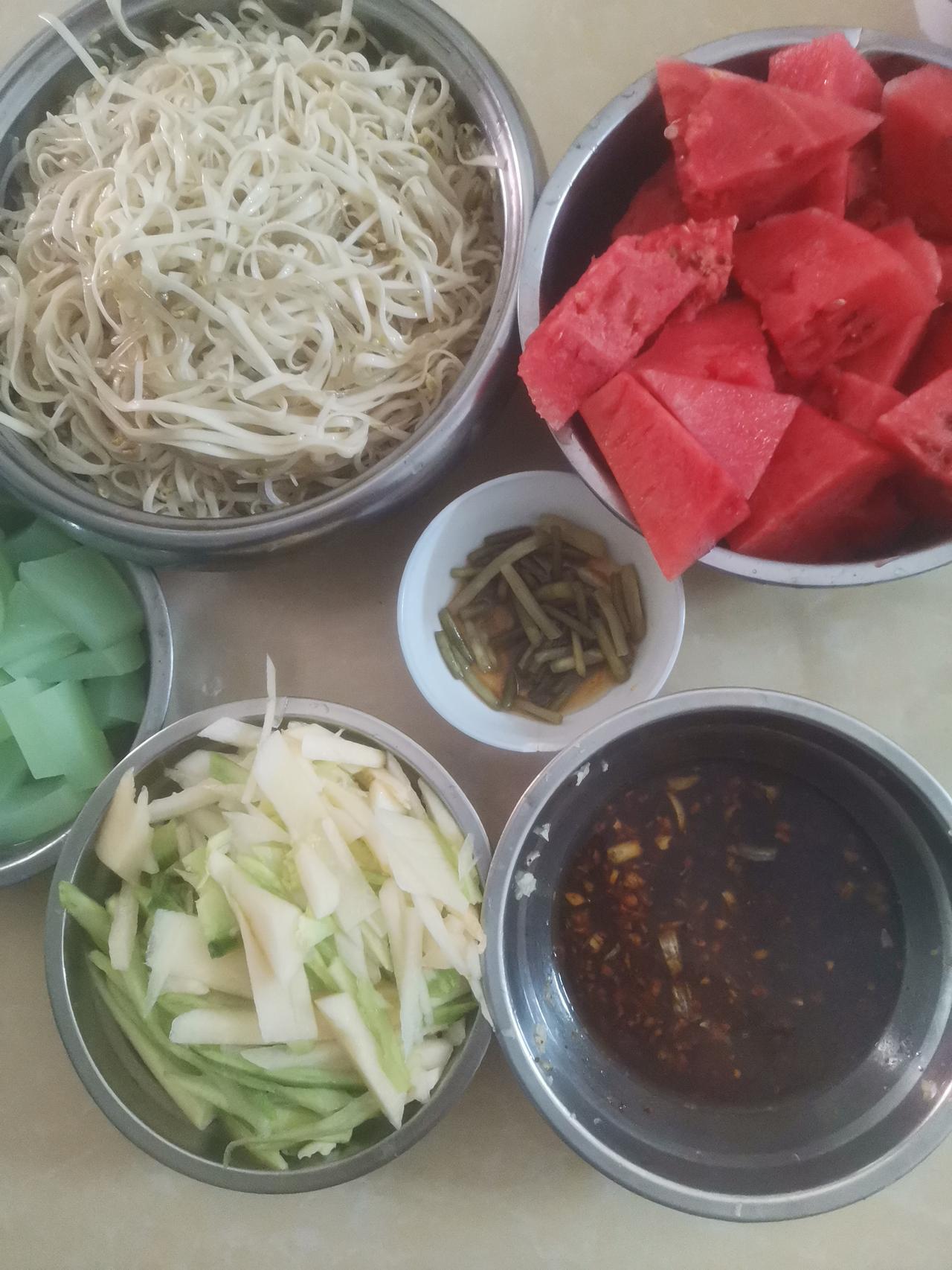 上午十点，来我妈家，我妈已经煮好面条了。
并且切好黄瓜和菜瓜条，拍了大蒜，兑好料